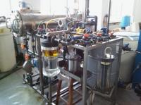 The photo shows a research installation of coalescing filters for fuel dehydration set up in the laboratory. The installation is built on a rack to which tubes, tanks and filters are properly attached.